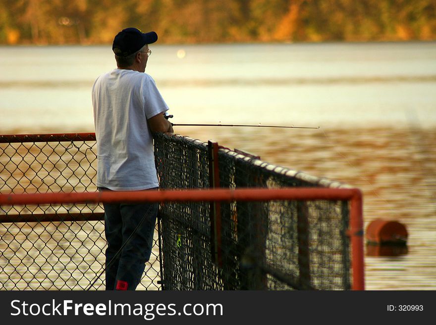 Man fising from dam platform on llake. Man fising from dam platform on llake