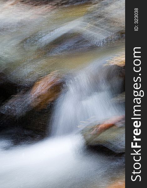 An abstract image of water flowing over rocks. An abstract image of water flowing over rocks.