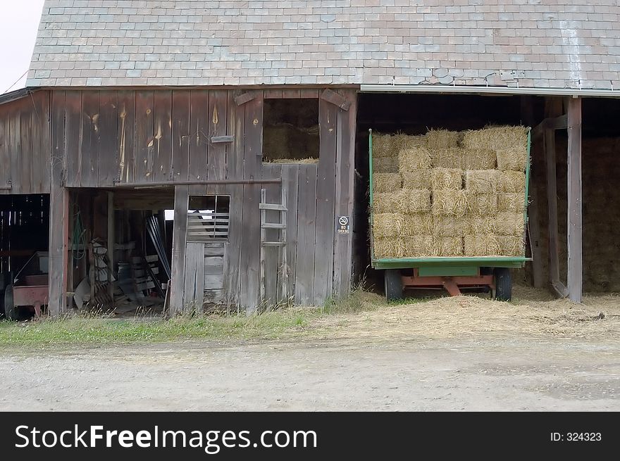 A barn with trailor, still loaded with hay. A barn with trailor, still loaded with hay