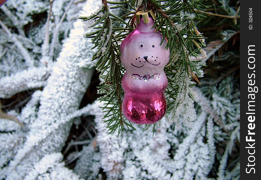 Christmas ornament dog hangs on the branch of fir tree, in background natural forest. Christmas ornament dog hangs on the branch of fir tree, in background natural forest