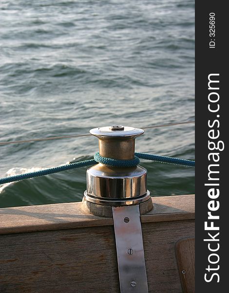Capstan on wooden deck. A rope is tied around capstan