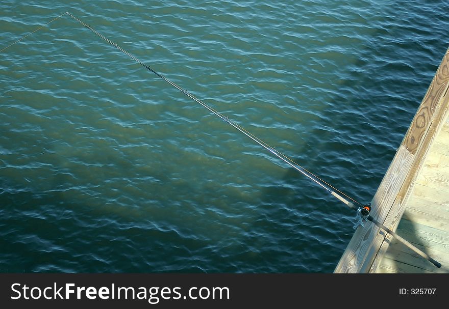 A fishing pole on a fishing pier.