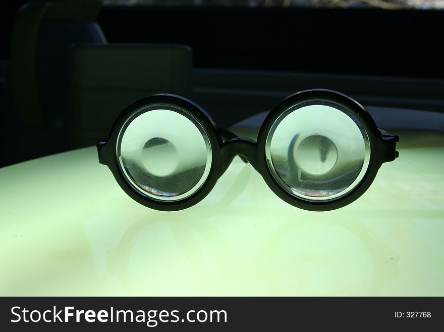 Glowing joke spex on bright surface with rather dark background. Glowing joke spex on bright surface with rather dark background