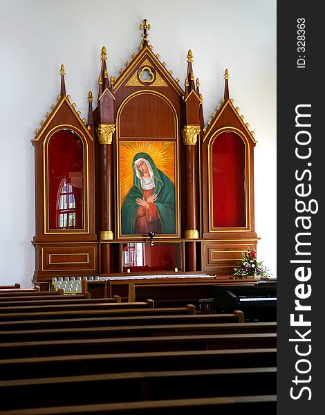 Inside of a catholic church with rows of seats in the foreground. Inside of a catholic church with rows of seats in the foreground.