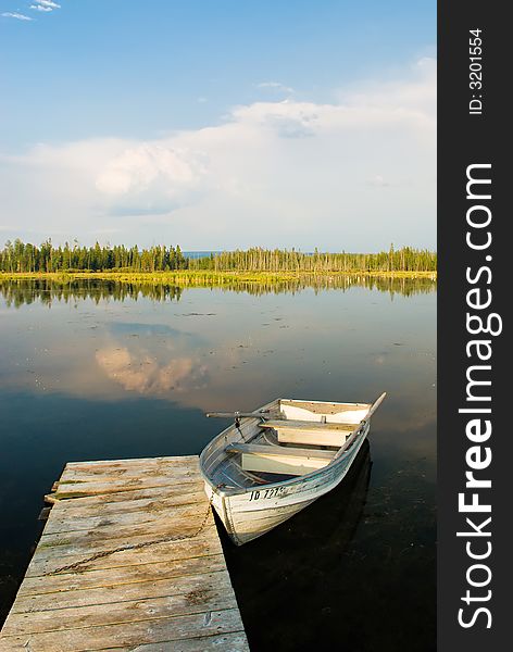 A picture of a boat docked in a peaceful lake in yellowstone national park