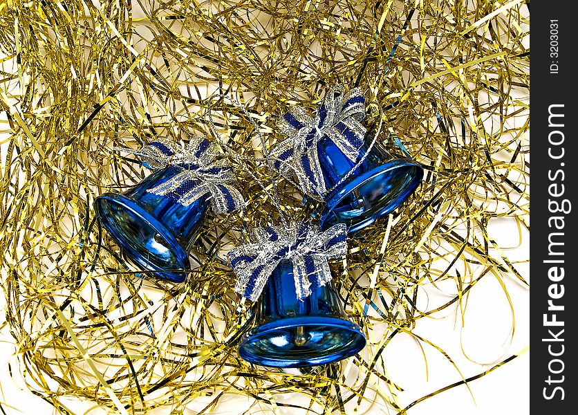 Three blue Christmas bells on a golden decorations, over white. Three blue Christmas bells on a golden decorations, over white