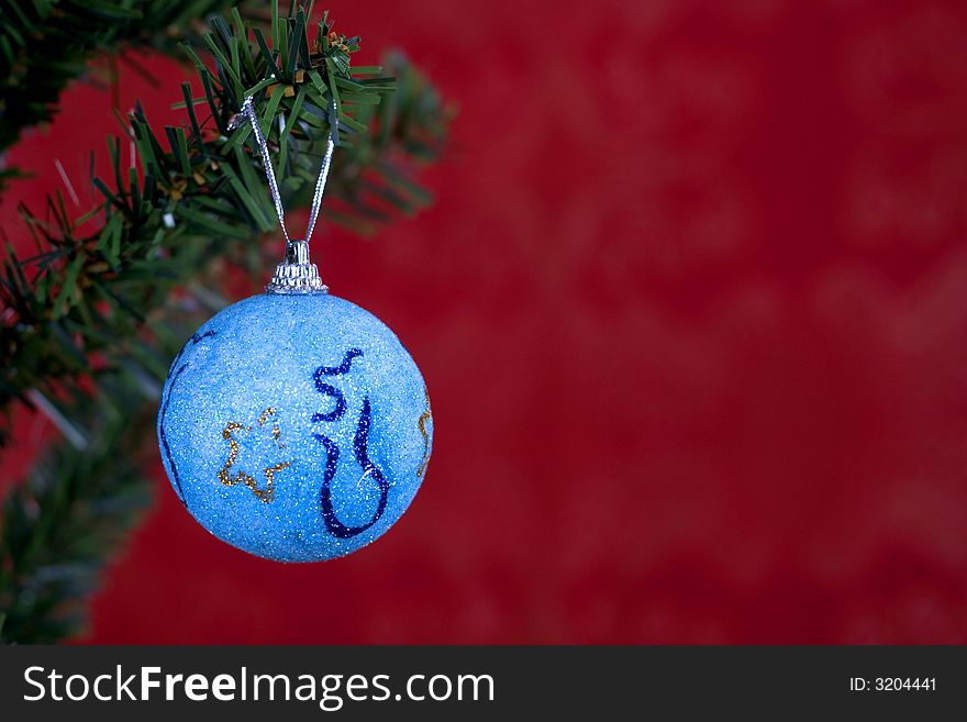 Blue christmas ball on red background