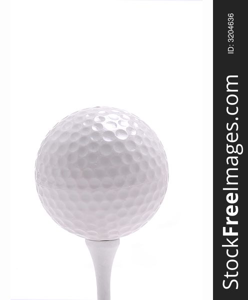 A golf ball rests on a tee.White Background. A golf ball rests on a tee.White Background.