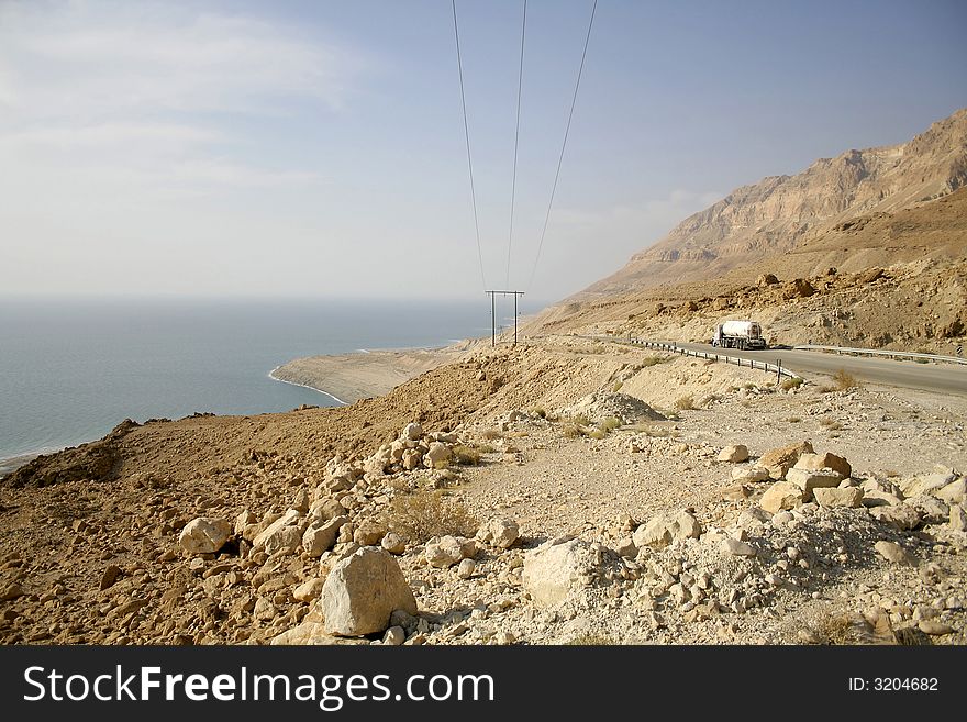 Truck following the desert road along the dead sea