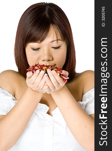 An attractive young Asian woman in white top holding red flowers on white background. An attractive young Asian woman in white top holding red flowers on white background