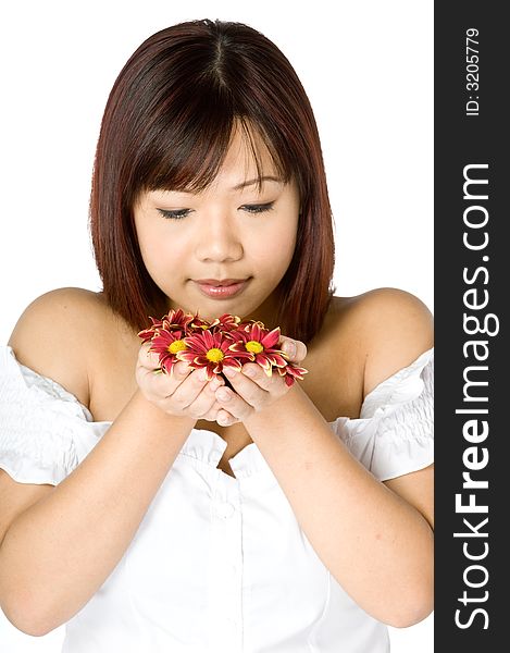 An attractive young Asian woman in white top holding red flowers on white background. An attractive young Asian woman in white top holding red flowers on white background