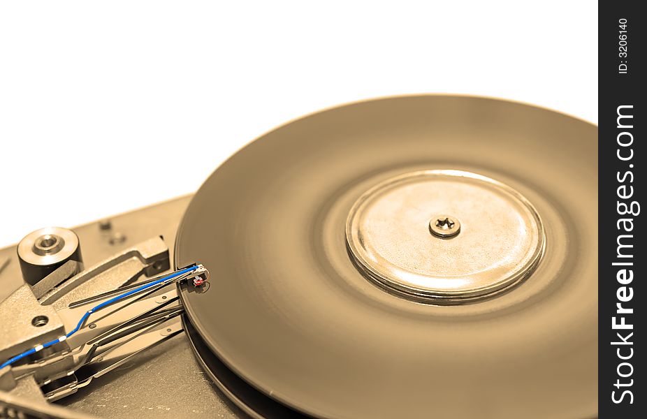 Close-up view of head and disk of HDD in sepia. Close-up view of head and disk of HDD in sepia