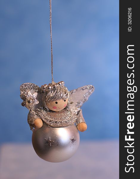 Silver toy angel on blue and white background,christmas decoration