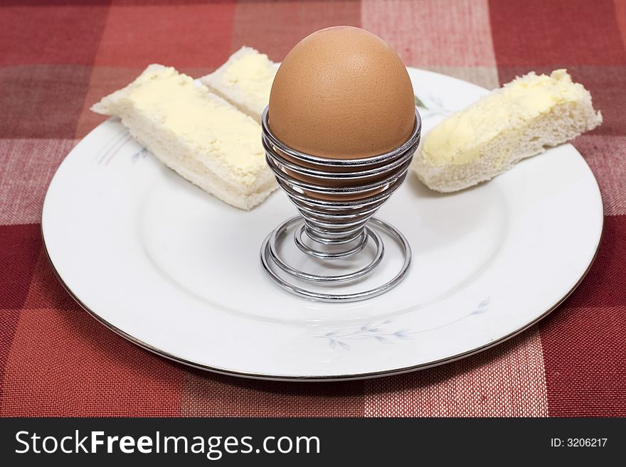 A boiled egg in egg cup with buttered soldiers. A boiled egg in egg cup with buttered soldiers