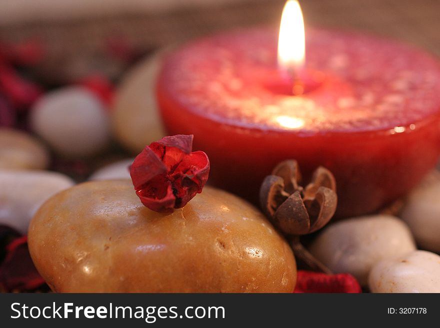 Stone with a red burning candle in the background