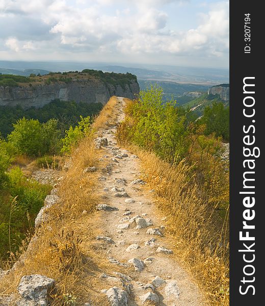 Pathway and precipice in mountains, cloudy sky. Pathway and precipice in mountains, cloudy sky