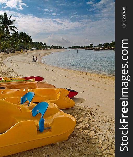 Water crafts for rental on an empty beach at a lagoon in a holiday resort earl in the morning.