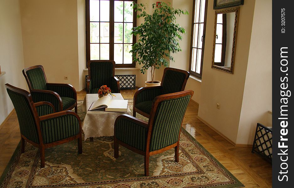 View at room with five chairs and table with a book. View at room with five chairs and table with a book