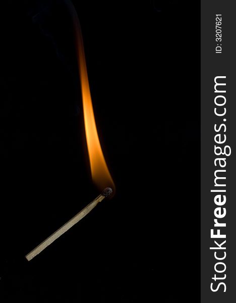 Burning match on black background