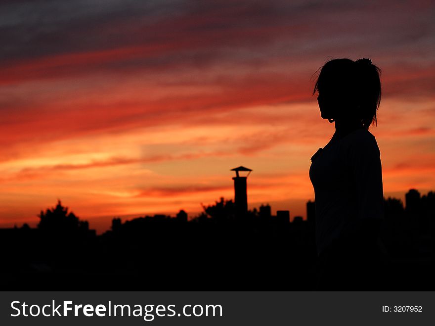 Lady on a rooftop looking at a beautiful sunset. Lady on a rooftop looking at a beautiful sunset.