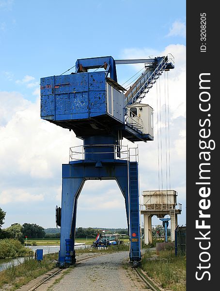 Crane for loading and unloading sand and shingle, supplied by ships over the river IJssel, near a factory to make cement. Crane for loading and unloading sand and shingle, supplied by ships over the river IJssel, near a factory to make cement.