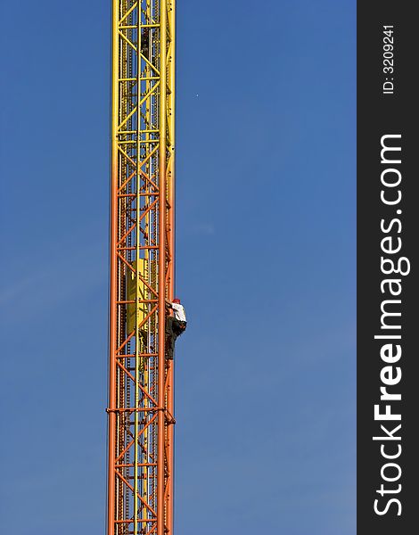 A contractor climbs high on a frame. A contractor climbs high on a frame