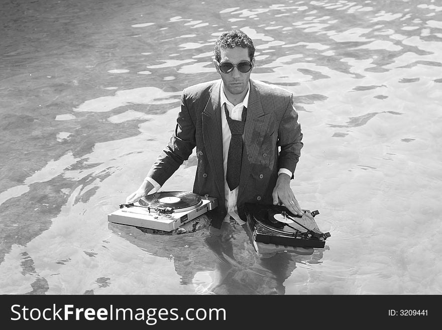 A young dj plays music in the sea. A young dj plays music in the sea