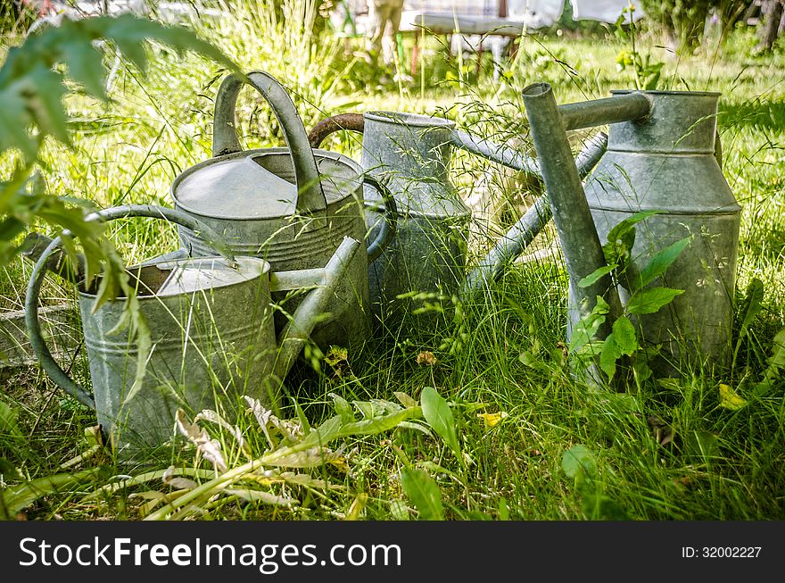 Old and rusty watering cans in a garden