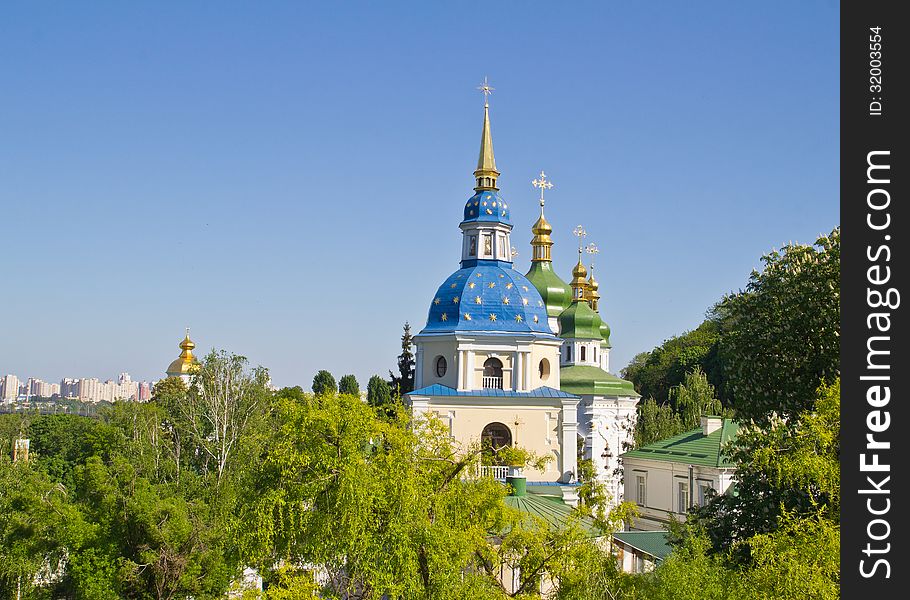 View of Vydubychi monastery buildings in green trees in spring. View of Vydubychi monastery buildings in green trees in spring