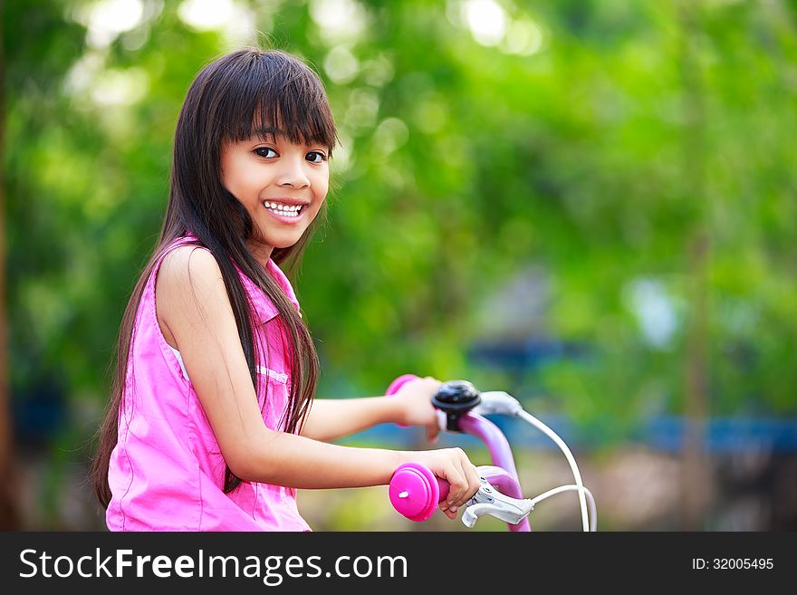 Little asian girl in a bicycle