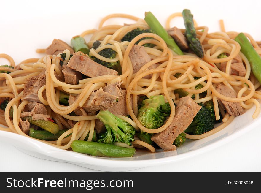 porc stir-fry on noodle with brocoli and asparagus