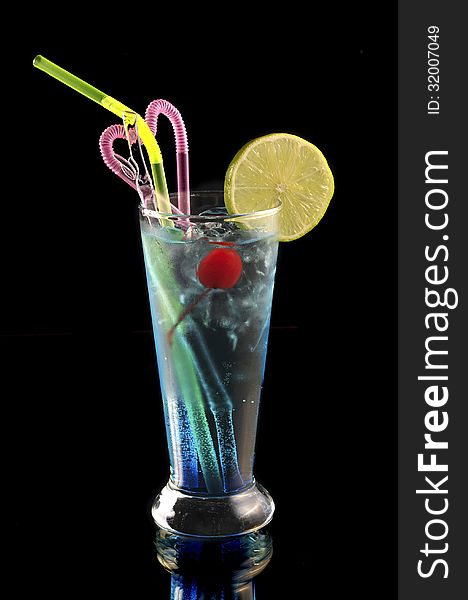 Blue cocktail with ice and lime on black