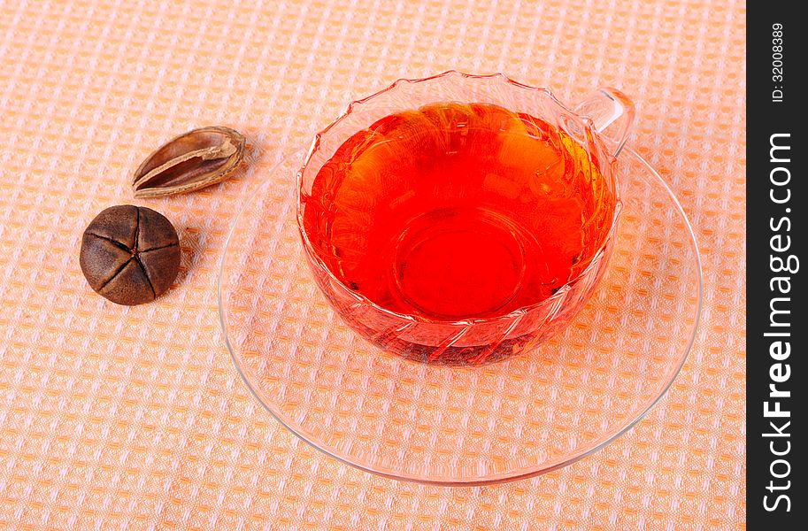 Tea in a glass cup, a glass saucer and decoration. Tea in a glass cup, a glass saucer and decoration