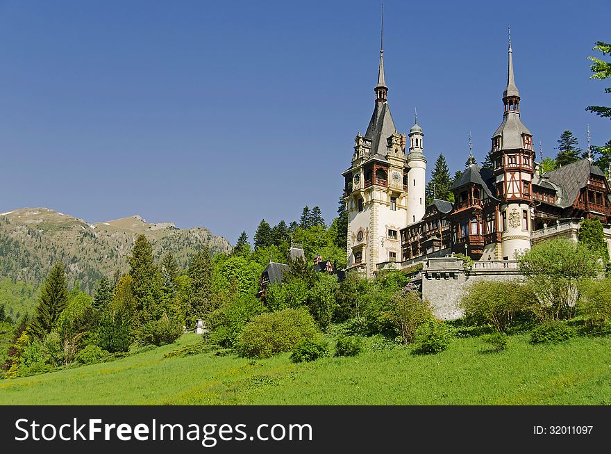 peles castle in sinaia with rhe carpathian mountains in the background, romania