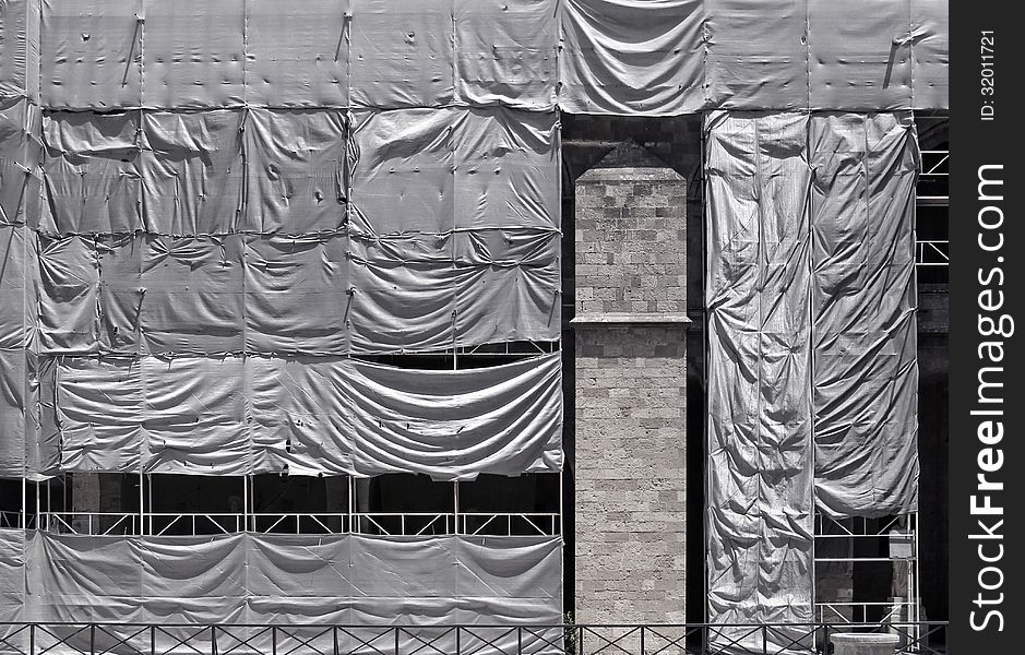 Building Covered With Wrinkled Tarpaulin Canvas