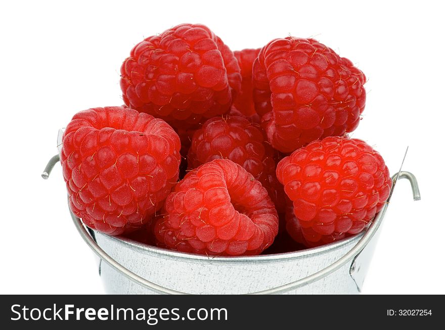 Perfect Ripe Raspberries in Cap of Tin Bucket isolated on white background. Perfect Ripe Raspberries in Cap of Tin Bucket isolated on white background