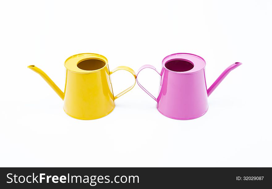 Pink and yellow water cans on white background.