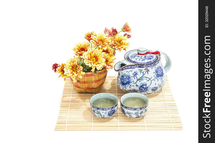 Teapot, cup and beautiful spring bouquet on a bamboo mat.