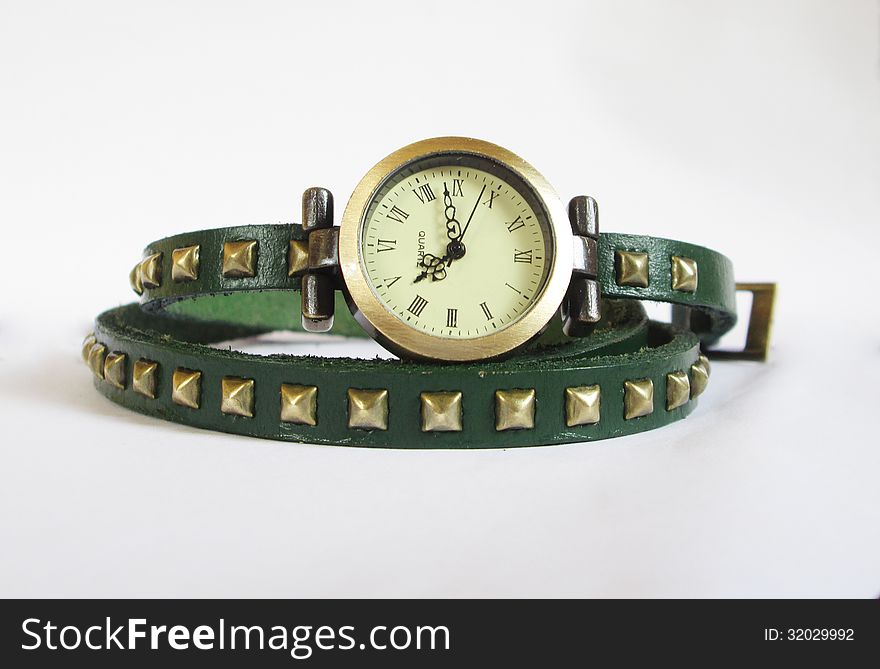 Quartz woman wrist watch with green leather strap on white background.