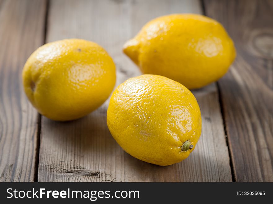 Ripe lemons on a wooden background. Ripe lemons on a wooden background