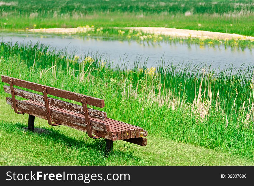 View of lake and empty old wooden bench. View of lake and empty old wooden bench