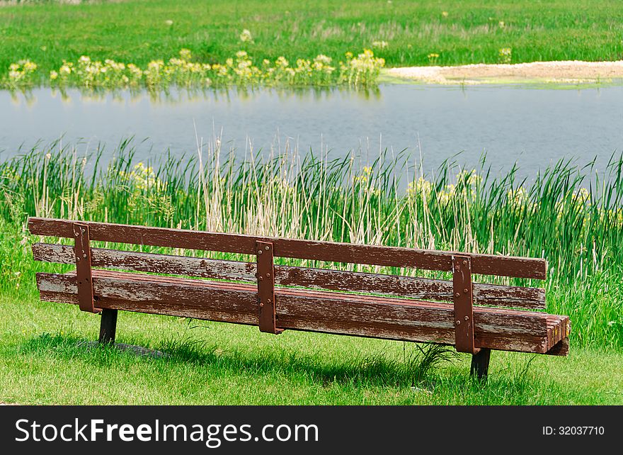 View of lake and empty old wooden bench. View of lake and empty old wooden bench