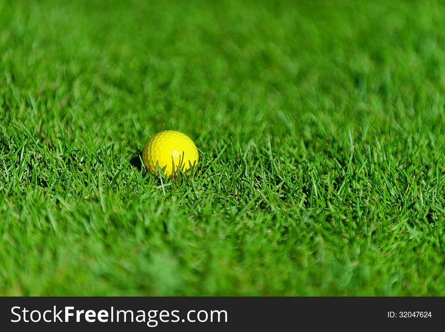Photo of yellow golf ball on green grass