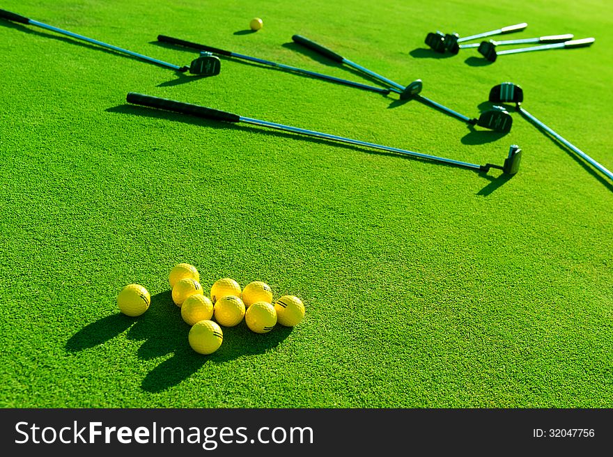 Iron golf club and golf ball on green grass