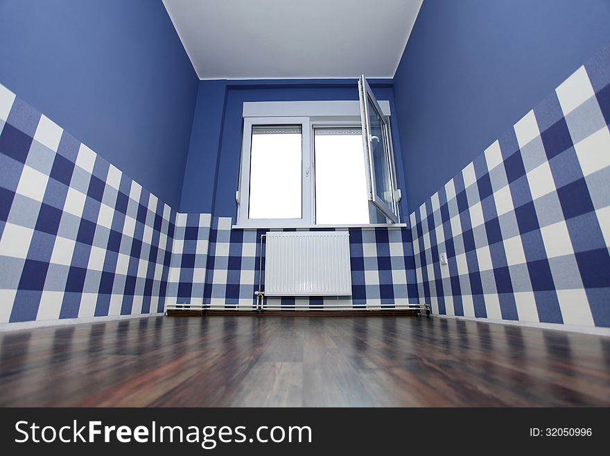 Empty room with a blue wall and blue-white wallpaper