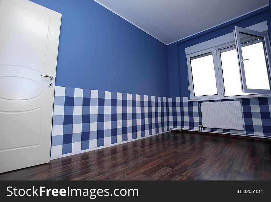 Empty room with a blue wall and blue-white wallpaper