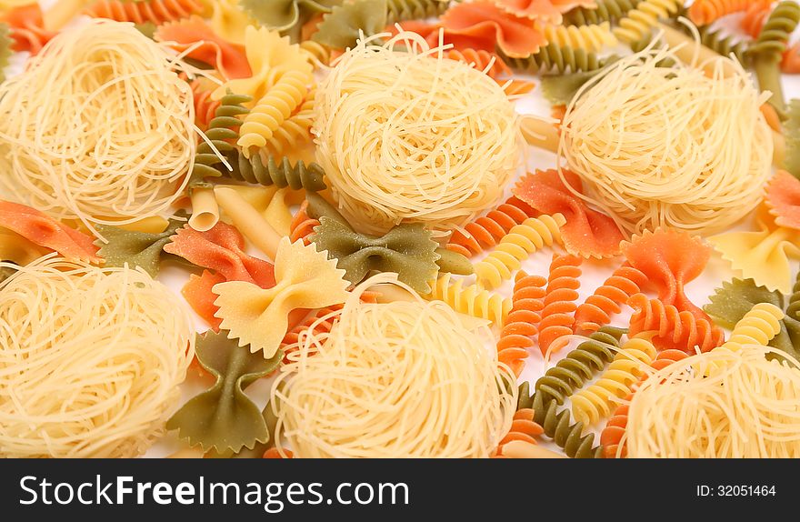 A different pasta in three colors close-up on the white background. A different pasta in three colors close-up on the white background.