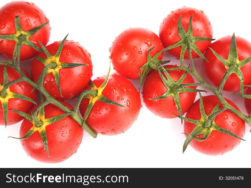 Two clusters of small red tomatoes on a branch isolated on a white background