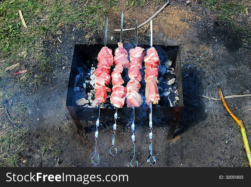 Barbecue grills over charcoal. bustier meat on a skewer. Barbecue grills over charcoal. bustier meat on a skewer