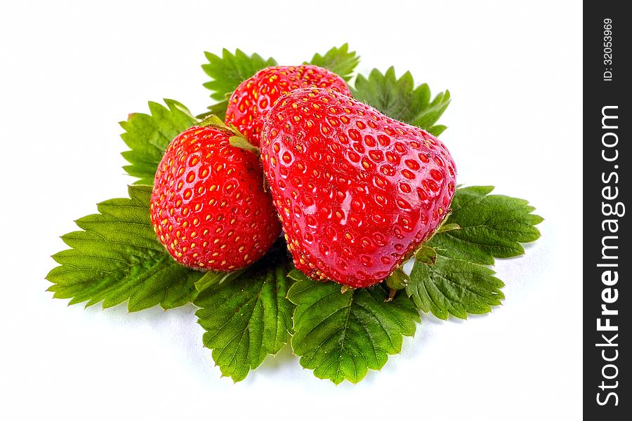 Whole strawberry and leaves on white